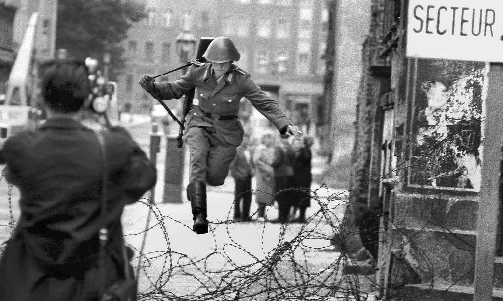 Hans Conrad Schumann, una guardia di frontiera orientale, ripreso mentre scappa durante la costruzione del Muro